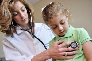 Doctor listening to child heartbeat
