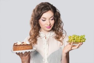 woman holding cake and grapes