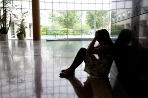 Person sitting against wall