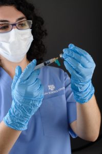 Nurse using a syringe