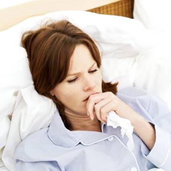 Exceptional Times/Woman Laying in Bed Holding Tissue Photo