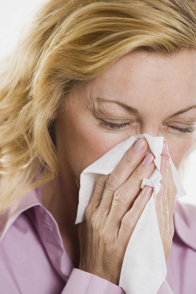 Complications/Woman Blowing Nose into Tissue Photo